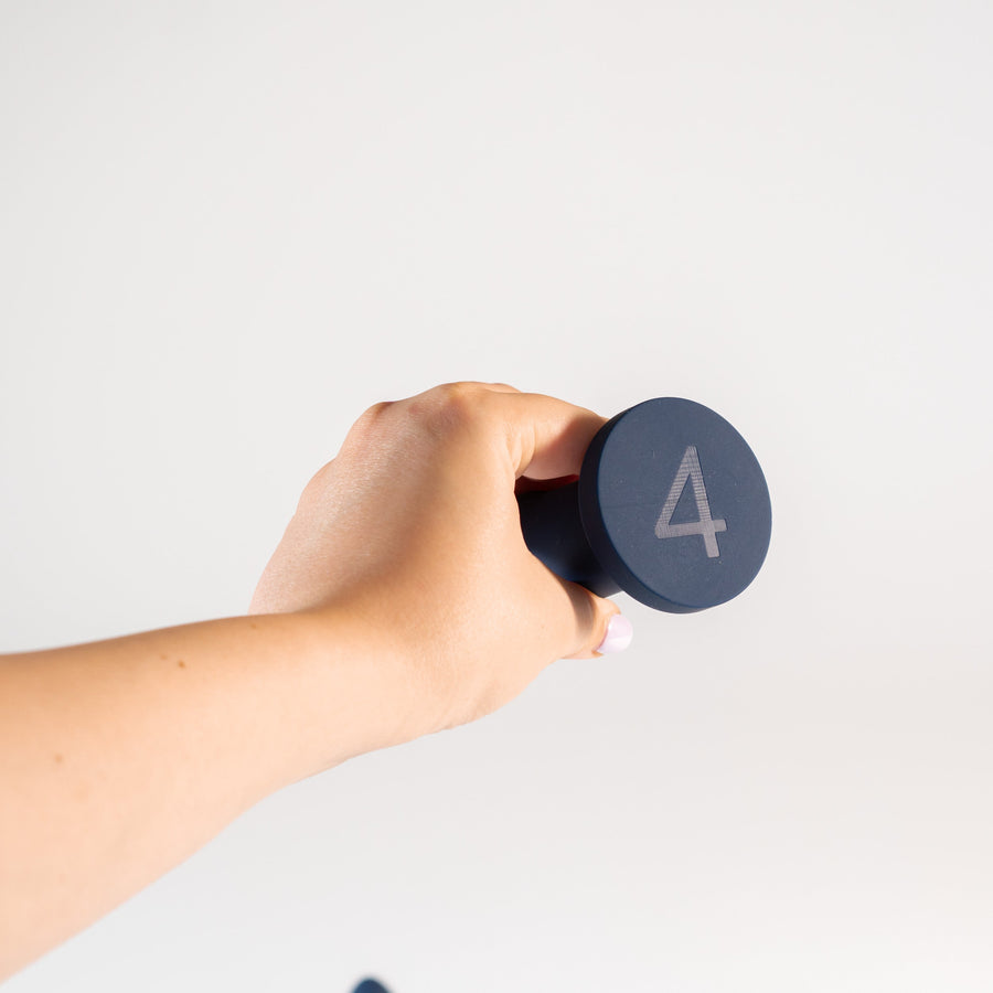 Hand holding a Slo.Mo plug, showing the laser-engraved size 4 on the base