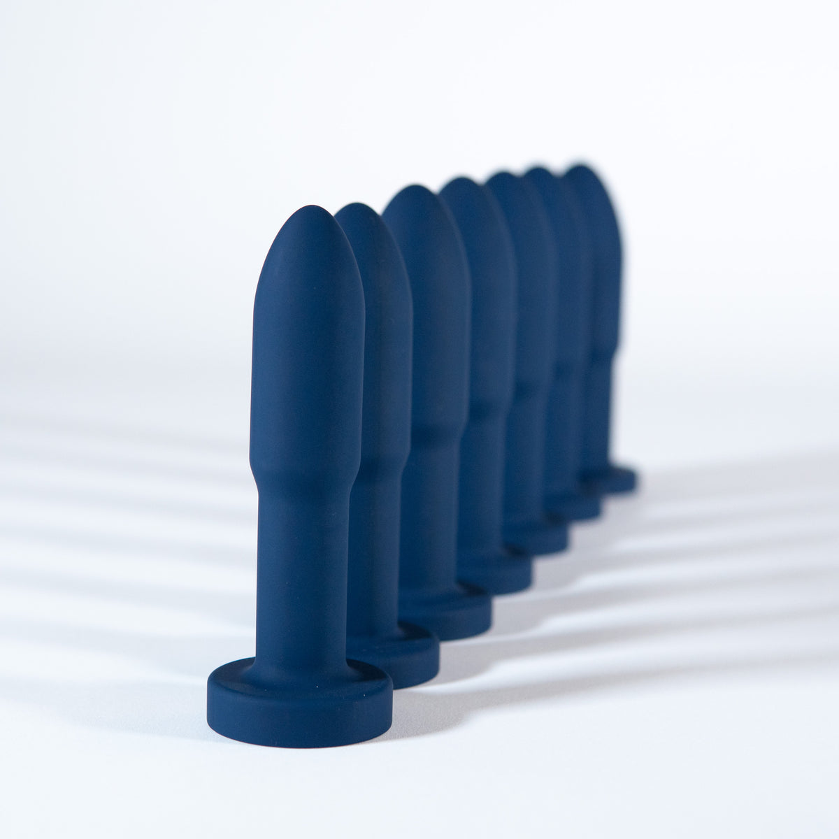 Seven Slo.Mo plugs in Midnight lined up from largest to smallest