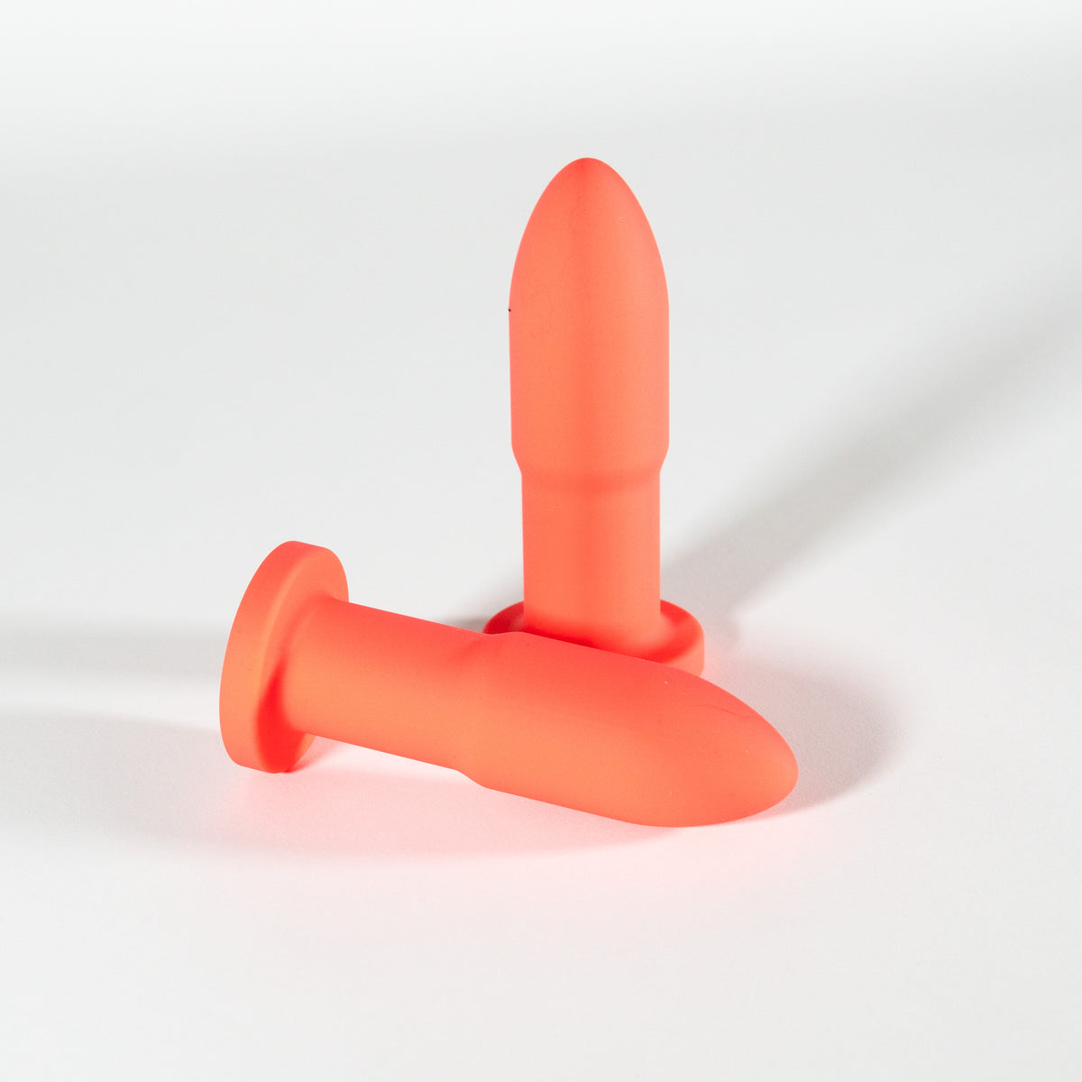 Two Slo.Mo plugs in Blush, one standing and one lying on its side