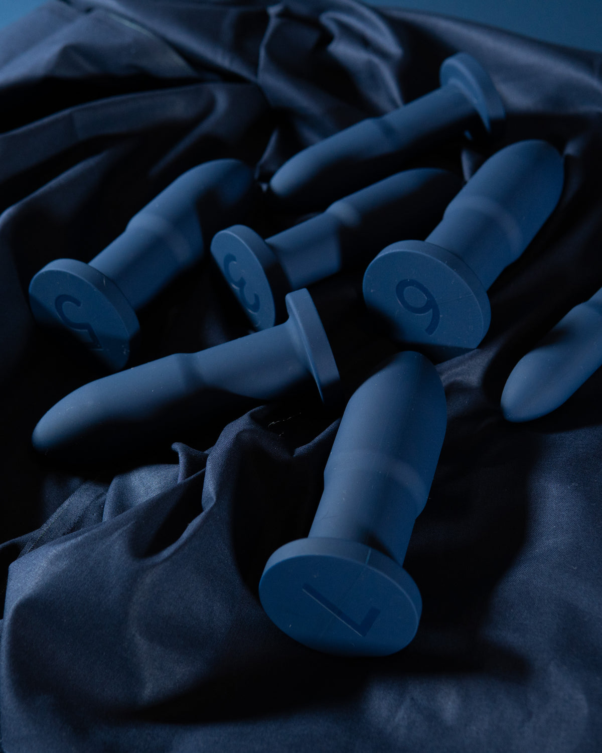 Slo.Mo plugs in Midnight scattered on dark blue fabric